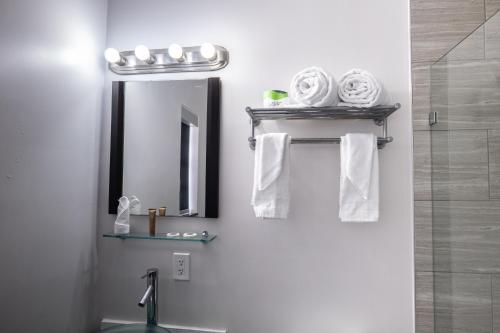 a bathroom with a sink and a mirror and towels at Fashion Boutique Hotel in Miami Beach