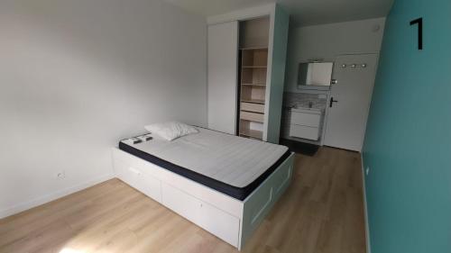 a small room with a bed and a kitchen at Appartement 5 chambres tous conforts - WIFI - TV in Saint-Étienne