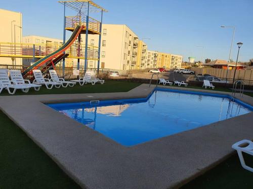 basen ze zjeżdżalnią i krzesłami oraz plac zabaw w obiekcie Casa de descanso w mieście Caldera