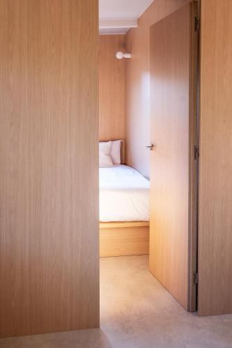 a room with a bed and a door leading to a bedroom at wecamp Santa Cristina in Santa Cristina d'Aro