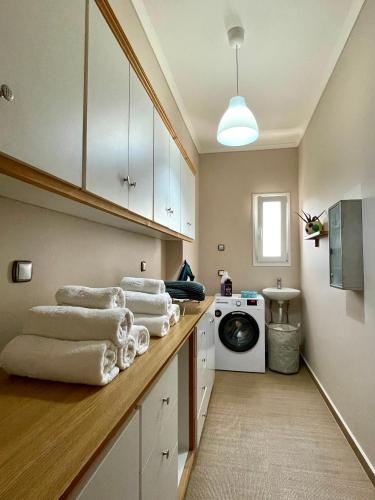 a laundry room with a stack of towels on a counter at Apollon Paian , Luxury Nature Relax in Lefkada