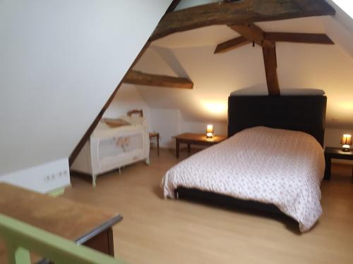 a bedroom with a bed in a room with a attic at Chez laiko wifi gratuit in Beaulieu-sur-Loire