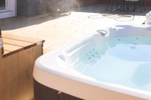 a bath tub in a room with a wooden floor at The Cottages at Blue - Cottage 3 in Blue Mountains