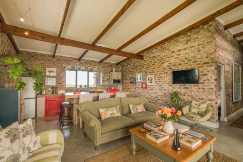 een open woonkamer met een bakstenen muur bij Libertas Guest Farm in Hoekwil