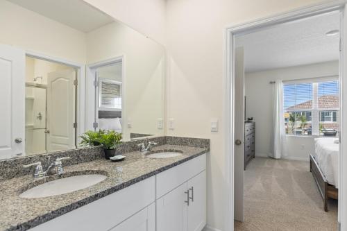 baño con 2 lavabos y espejo grande en 7579 Solterra by Orlando Holiday Rental Homes, en Loughman