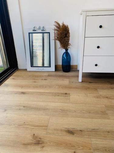 Cette chambre dispose de parquet, d'un miroir et d'une commode. dans l'établissement Canet-Plage Houstal Résidence, à Canet