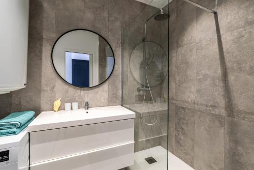 une salle de bain avec un lavabo et un miroir dans l'établissement Magnifique appartement vue mer, spacieux et traversant, à Ajaccio