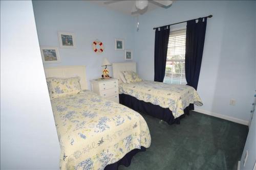 a bedroom with two beds and a window at 613 River Crossing Condo in North Myrtle Beach
