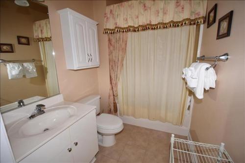 a bathroom with a white sink and a toilet at 613 River Crossing Condo in North Myrtle Beach