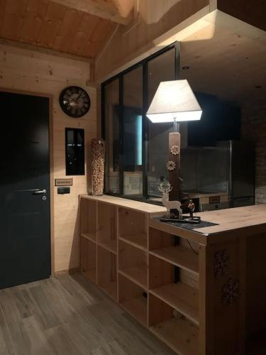 une cuisine avec un comptoir et une horloge au mur dans l'établissement Appartement de montagne cosy, à Angoustrine