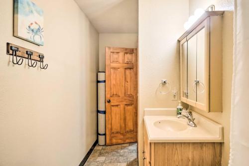 ein Badezimmer mit einem Waschbecken und einer Holztür in der Unterkunft Serene Kenai Condo Less Than 4 Mi to Kenai Beach! in Kenai