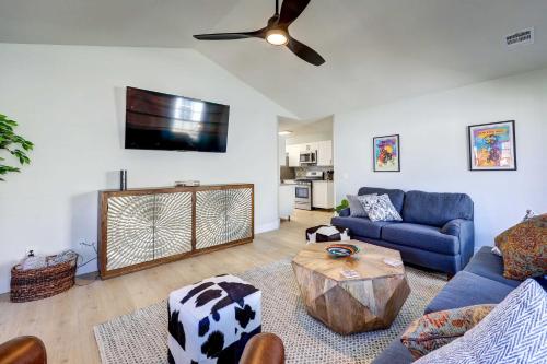 a living room with a blue couch and a ceiling fan at Chic Bentonville Home with Patio and Fire Pit! in Bentonville