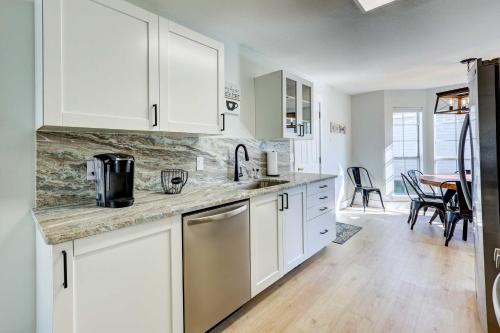 a kitchen with white cabinets and a counter top at Chic Bentonville Home with Patio and Fire Pit! in Bentonville