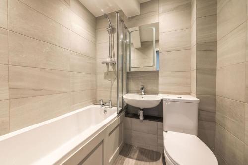 エディンバラにあるLuxury Castle View 3 Bedroom 2 Bathroom Apartmentのバスルーム(トイレ、洗面台、バスタブ付)