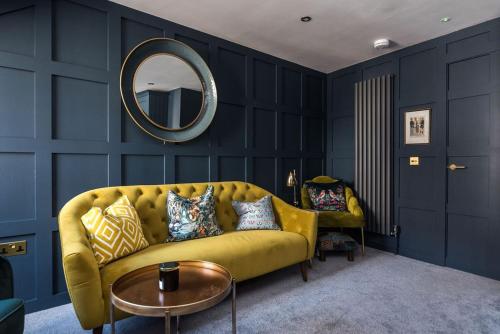 a living room with a yellow couch and a mirror at Luxury Castle View 3 Bedroom 2 Bathroom Apartment in Edinburgh
