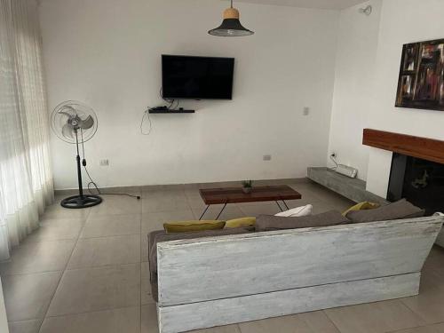 een woonkamer met een bank en een flatscreen-tv bij Alquiler de casa zona Cerro in Cordoba