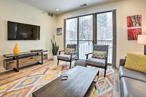 a living room with a couch and chairs and a tv at Traverse City Condo Half Mi to Front Street! in Traverse City
