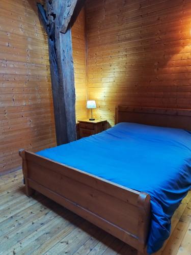 une chambre avec un lit dans une cabane en rondins dans l'établissement Appartement chaleureux à Blaignac avec piscine partagée - 55 m², à Blaignac