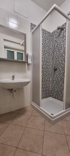 uma casa de banho com um chuveiro e um lavatório. em Ostello Giovane Europa di Trento em Trento