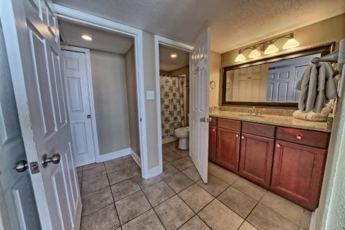 a bathroom with a sink and a toilet and a mirror at Dunes of Panama in Panama City Beach
