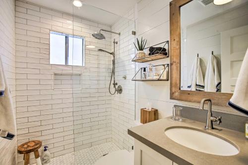 ein weißes Badezimmer mit einem Waschbecken und einem Spiegel in der Unterkunft Waterfront Hitchcock Home with Spacious Deck! in Hitchcock