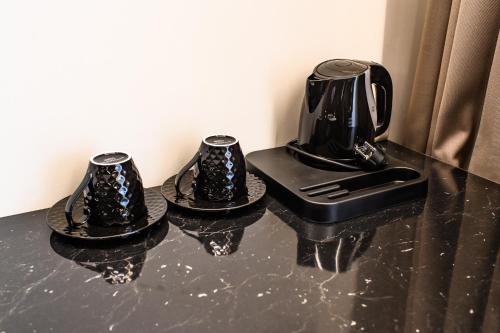 two black coffee makers on a black counter top at Diamond svečių namai in Kaunas