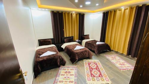 a hotel room with three beds and curtains at Petra Olive House in Wadi Musa