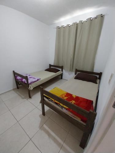 a room with two beds and a curtain at AGUA MAIS in Campos dos Goytacazes
