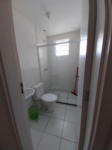 a white bathroom with a toilet and a window at AGUA MAIS in Campos dos Goytacazes