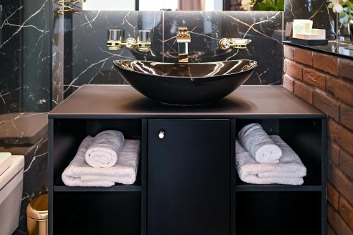 a bathroom with a bowl sink and towels at Diamond svečių namai in Kaunas