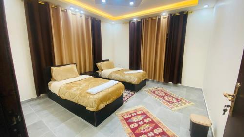 a room with two beds and a chair in it at Petra Olive House in Wadi Musa