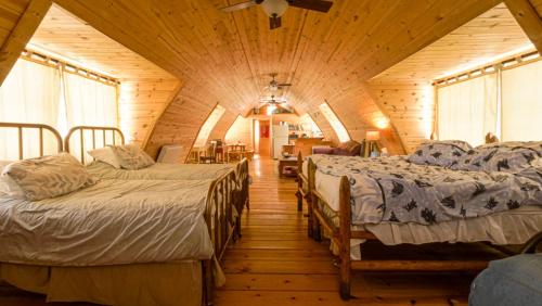 una camera con tre letti in una cabina di legno di Aubin Sky Lodging at the YL Ranch a Savery