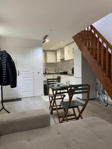 un salon avec une table et des chaises et une cuisine dans l'établissement Appart95 Saint-Brice CDG France, à Saint-Brice-sous-Forêt