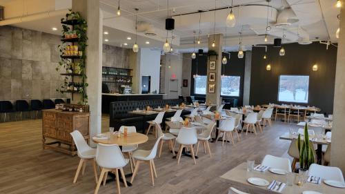 a restaurant with tables and chairs and a bar at Divya Sutra Plaza and Conference Centre Calgary Airport in Calgary