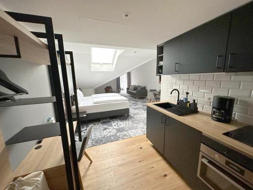 una cucina e un soggiorno con un letto in una camera di Alpenglühen Smart Hotel a Olching