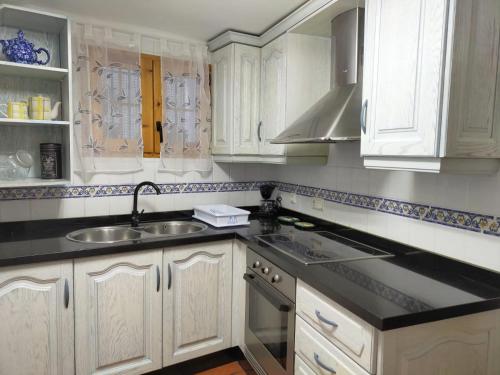 a kitchen with white cabinets and a sink at Can Mari in Ayna