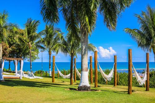 a park with hammocks and palm trees on the beach at Porto Seguro Eco Bahia Hotel in Porto Seguro