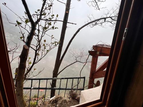 uma janela com vista para uma árvore e montanhas em Rooms Nesti INSIDE OF CASTLE em Krujë