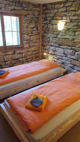 duas camas num quarto com uma parede de pedra em Haus Corina em Klosters