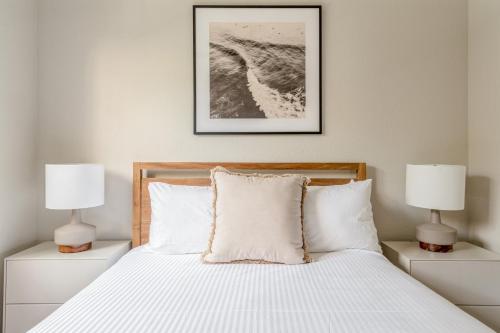 a bedroom with a white bed with two lamps at Kasa Wellington South Florida in Wellington