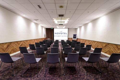 a room with rows of chairs in front of a screen at Novotel Birmingham Centre in Birmingham