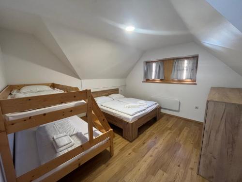 two bunk beds in a room with wooden floors at Apartments Prekmurska vas - Vital Resort in Moravske Toplice