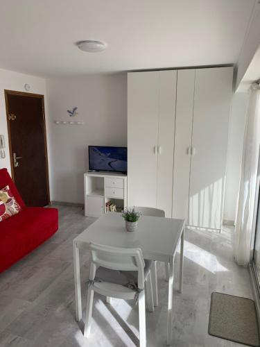 un salon avec une table et un canapé rouge dans l'établissement Baie Island à 50 m de la plage…, à Fort-Mahon-Plage