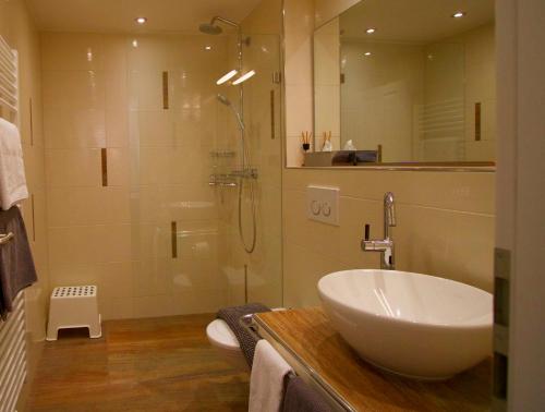 ein Badezimmer mit einem Waschbecken und einer Dusche mit einer Glastür in der Unterkunft Landhaus Heuchen in Reit im Winkl
