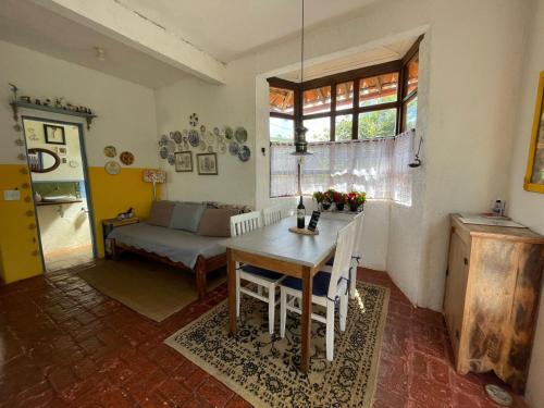 un salon avec une table et un canapé dans l'établissement Casa das Orquídeas, à Lavras Novas