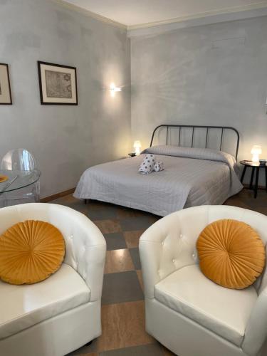 ein Schlafzimmer mit zwei weißen Stühlen und einem Bett in der Unterkunft Accademia Dream in Bergamo