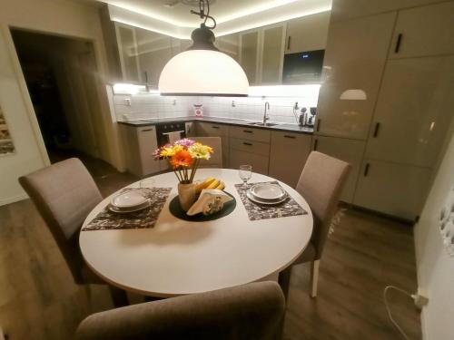a white dining room table with chairs and flowers on it at Exklusiv flat with office 25 min from Östersund in Ytterån