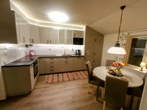 a kitchen and dining room with a table and chairs at Exklusiv flat with office 25 min from Östersund in Ytterån