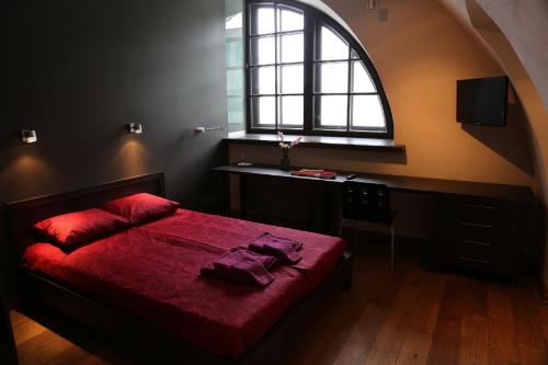 ein Schlafzimmer mit einem roten Bett und einem Fenster in der Unterkunft Daugavpils Mark Rothko Art Center residences in Daugavpils