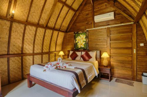 a bedroom with a bed in a wooden room at The Catar Cottages in Nusa Penida